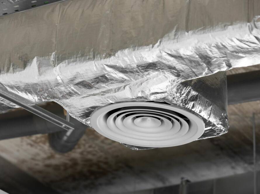 HVAC technician inspecting a section of exposed ductwork for air leaks