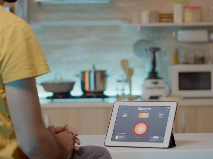 Handheld indoor air quality monitor displaying readings on a kitchen counter